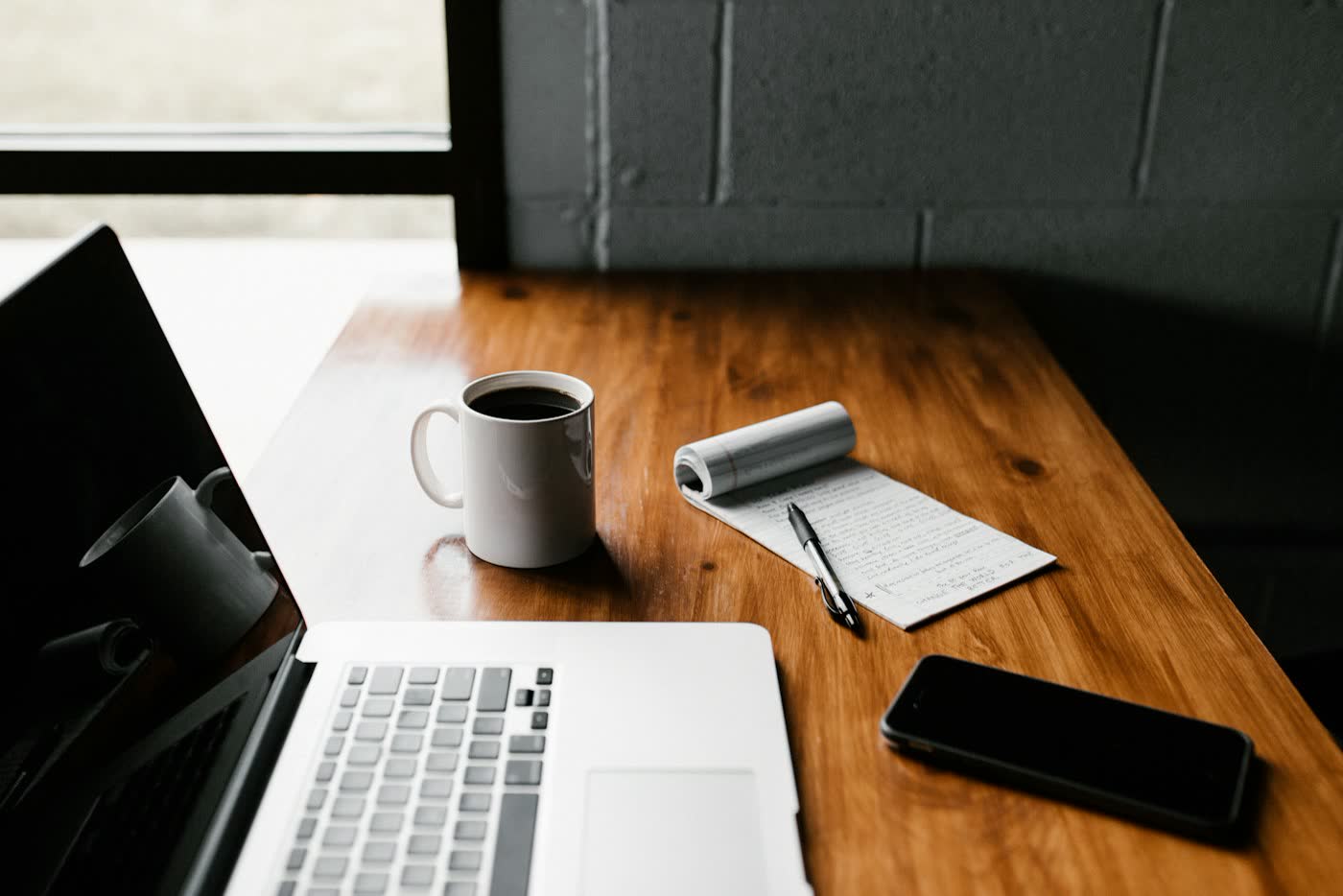 Escritorio con portátil, café y libreta